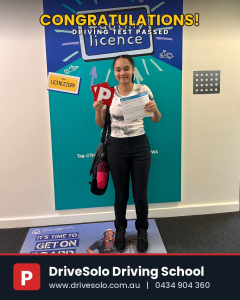 Young woman holding P plates and licence after passing driving test with DriveSolo Driving School in Kelmscott